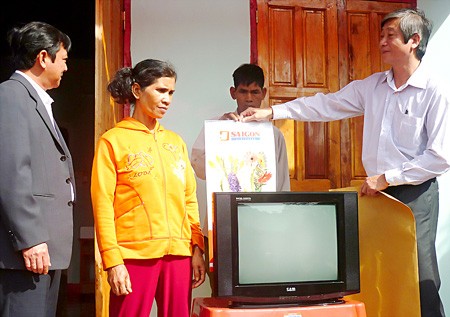 A representative from Sai Gon Giai Phong (R) hands over gratitude houses and television sets to residents from the Duc Co District, Gia Lai Province on January 12. (Photo:SGGP)